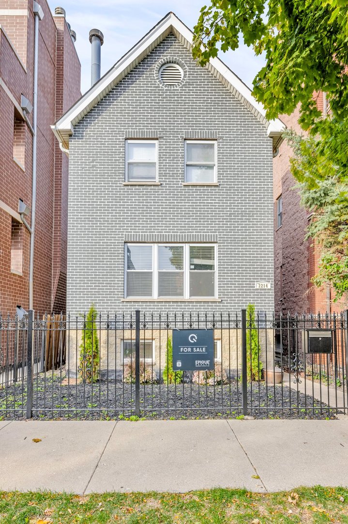 a front view of a house with glass windows and fence