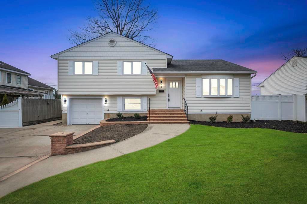 Tri-level home with a garage and a lawn