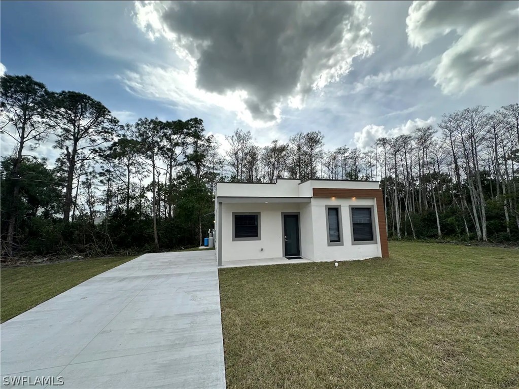 a front view of a house with yard and trees