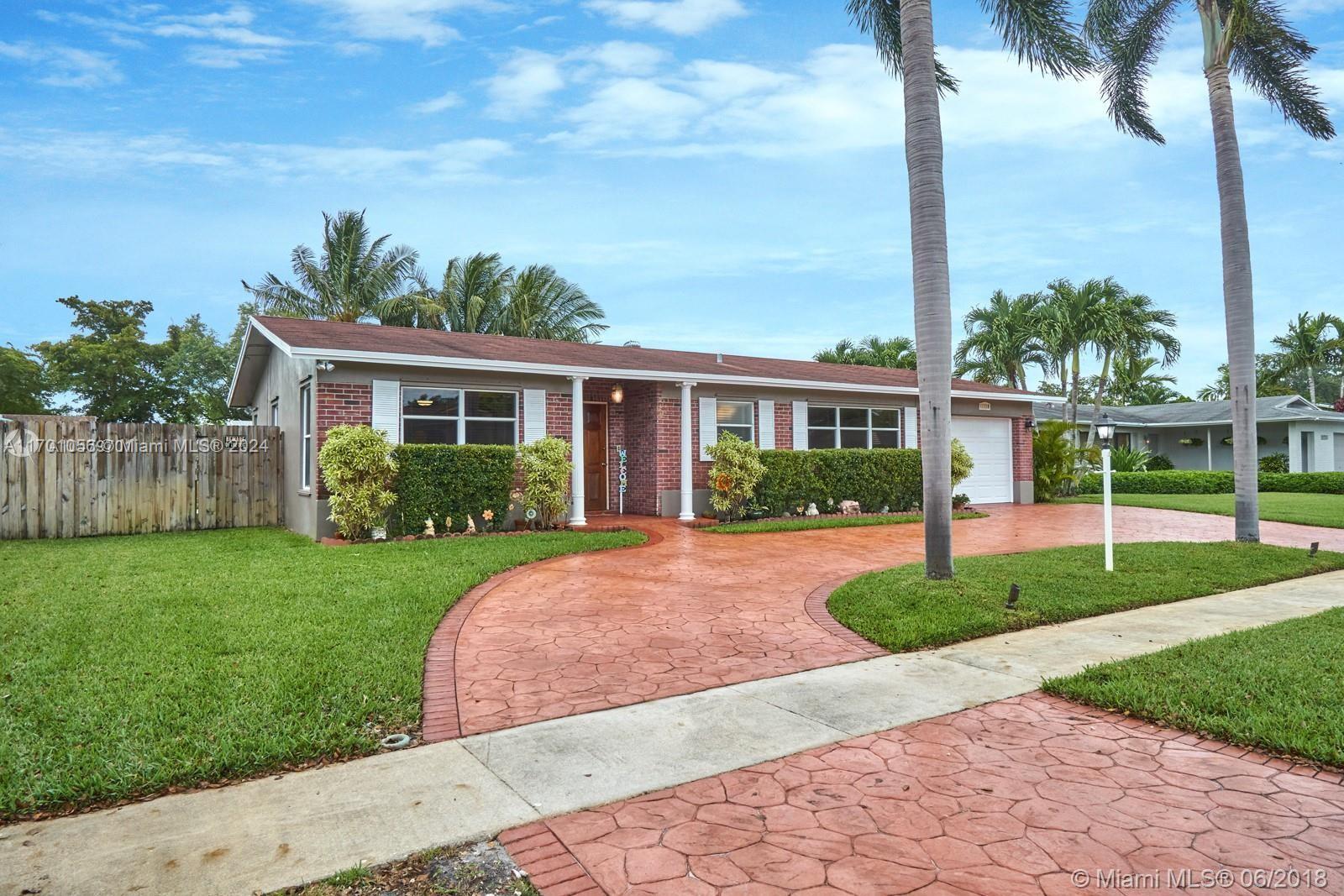 a view of a house with a yard and palm trees