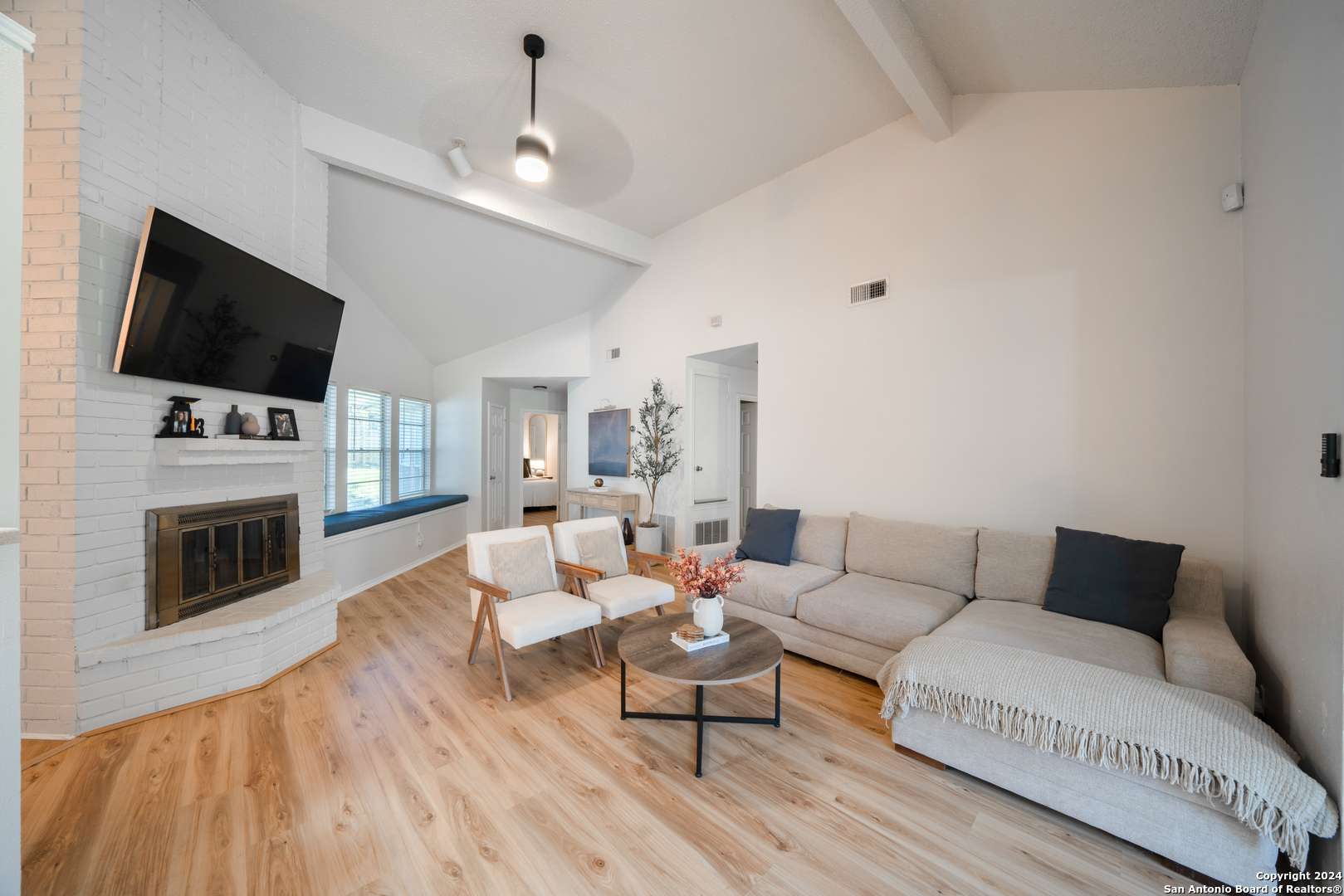 a living room with furniture a fireplace and a flat screen tv