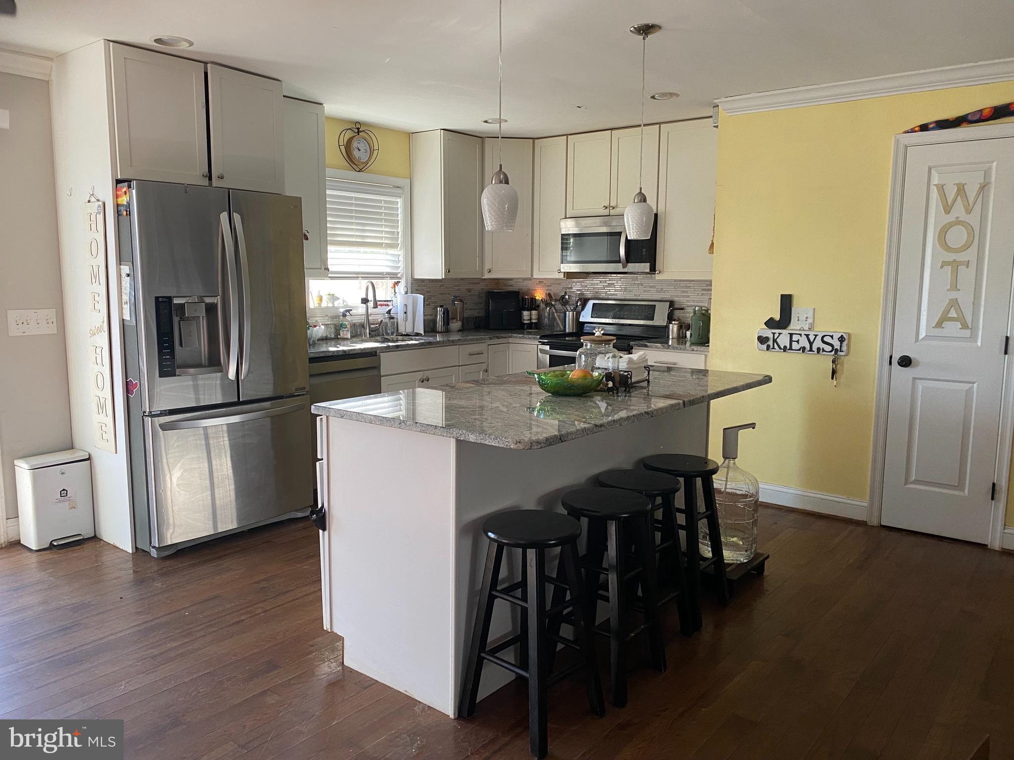 a kitchen with kitchen island a refrigerator stove microwave and cabinets