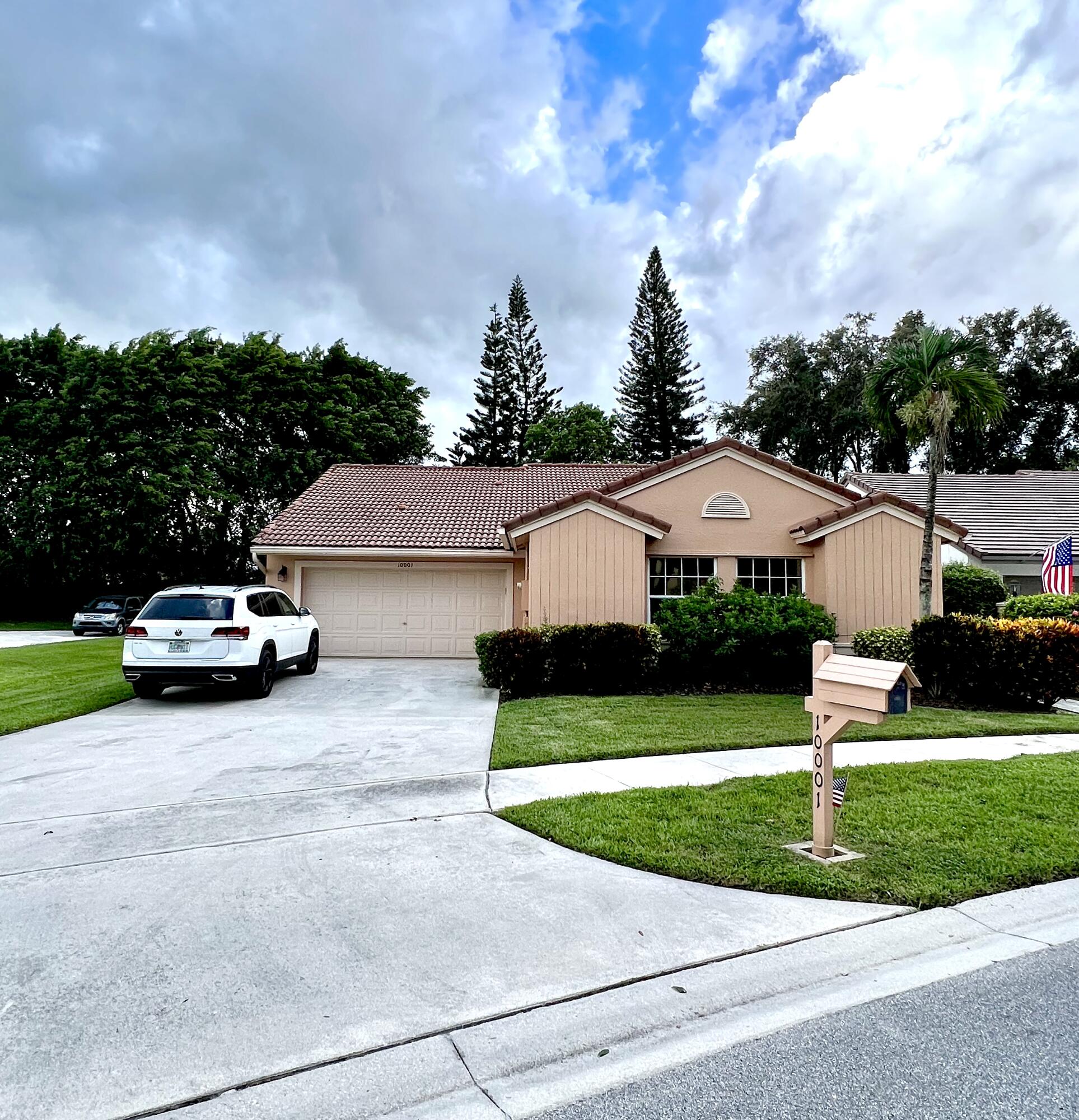 a car parked in front of a house with a yard