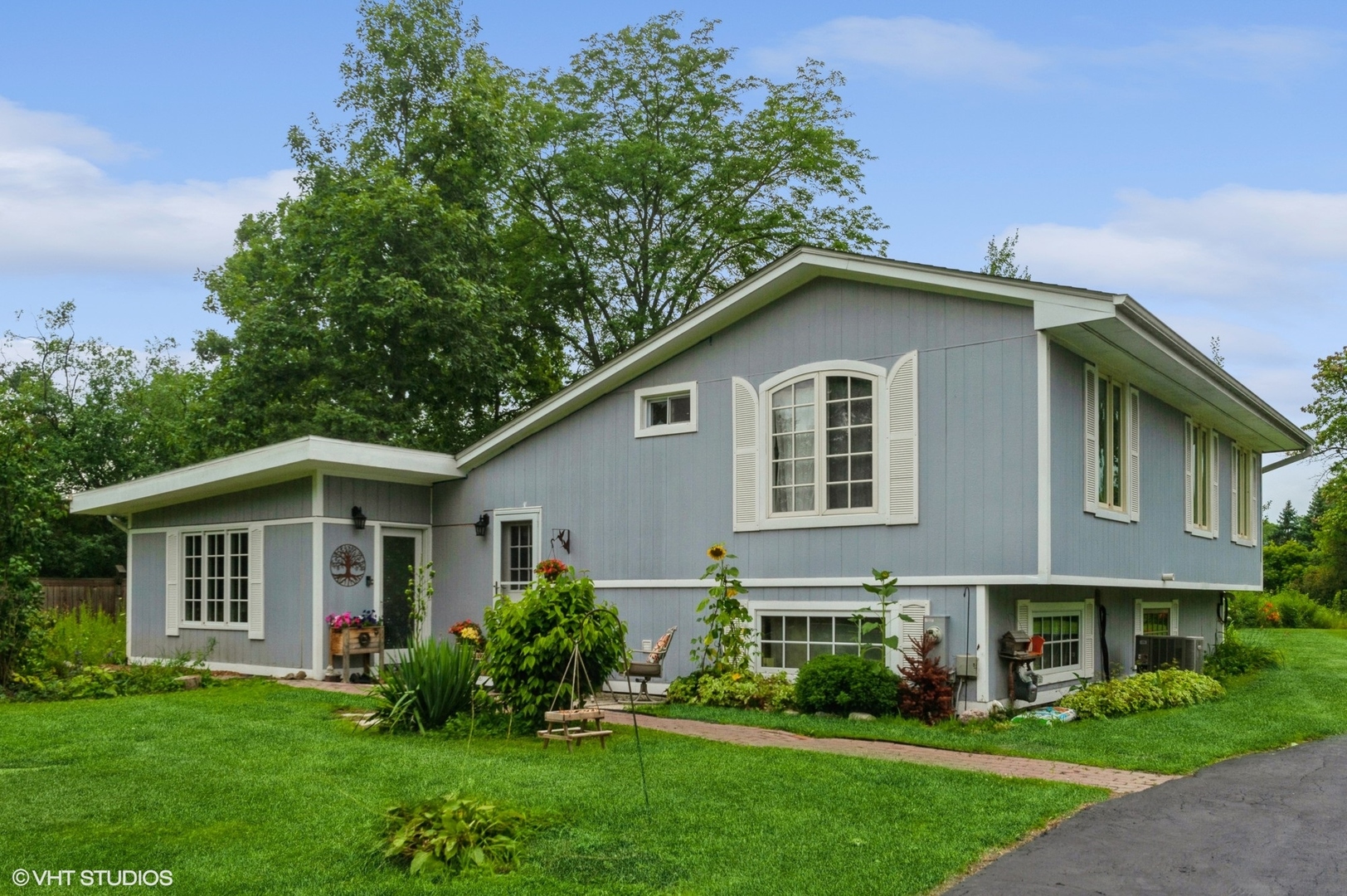 a front view of a house with a garden and plants