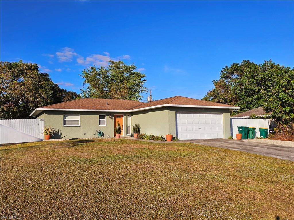 Single story home with a garage and a front yard