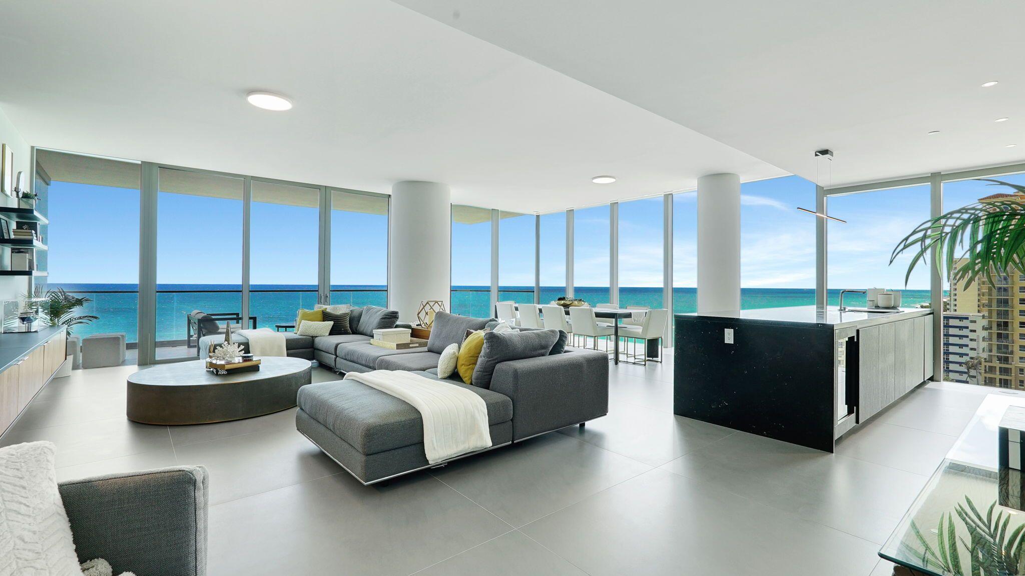 a living room with couches and kitchen view with wooden floor