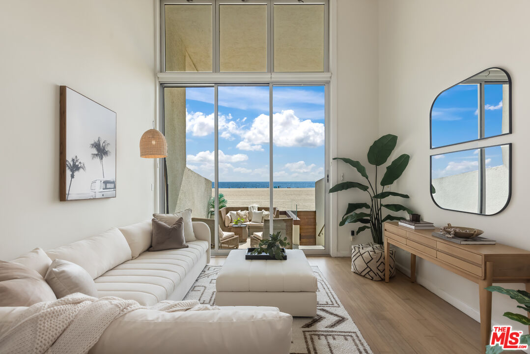 a living room with furniture a window and potted plants