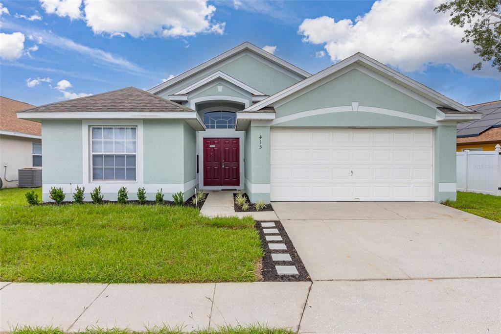 a front view of a house with a yard and garage