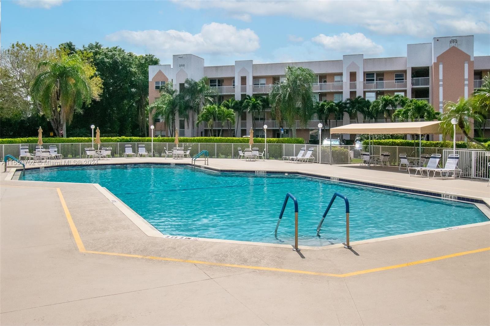 a swimming pool with outdoor view and trees in the background