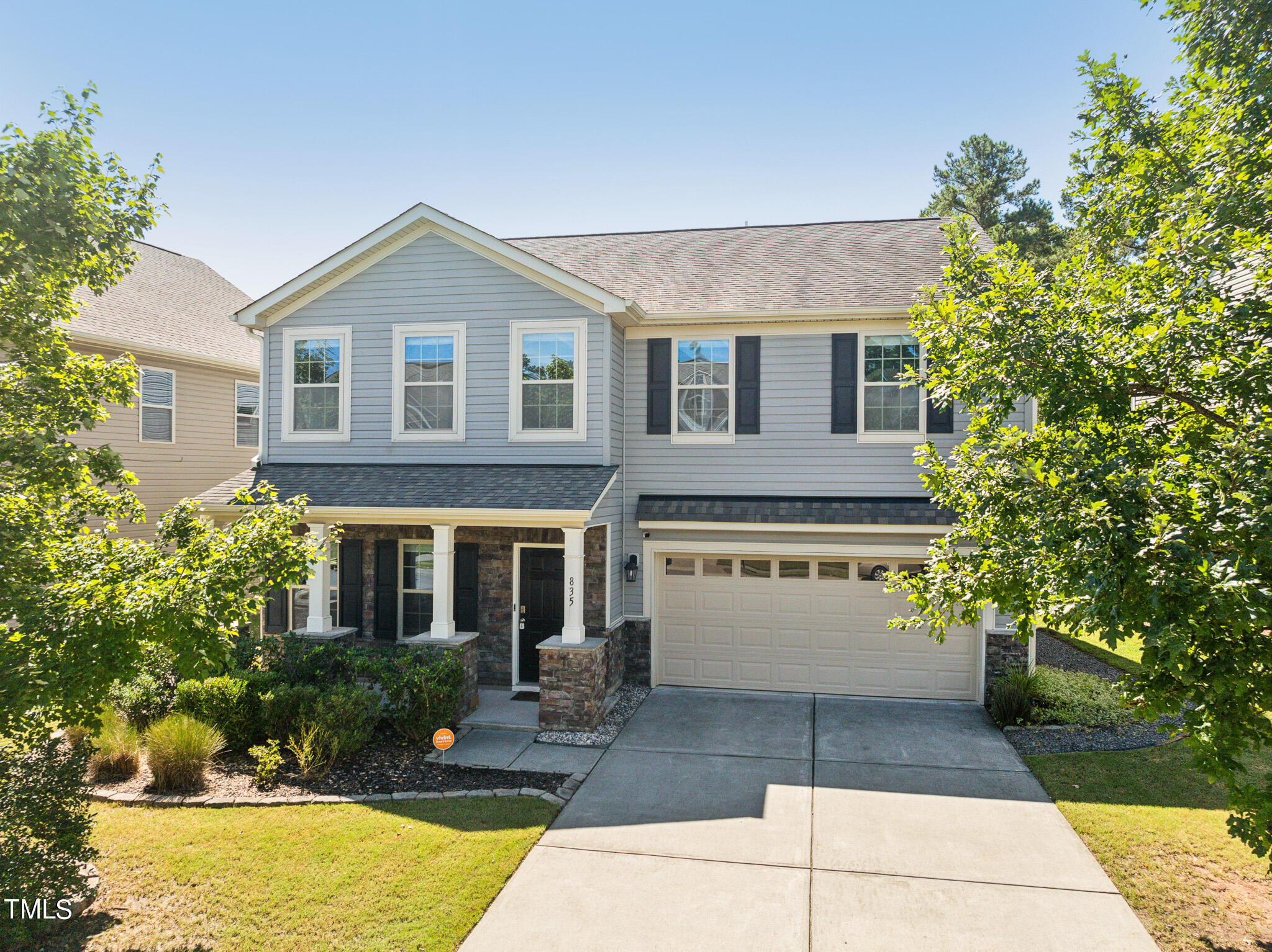 a front view of a house with a yard and trees