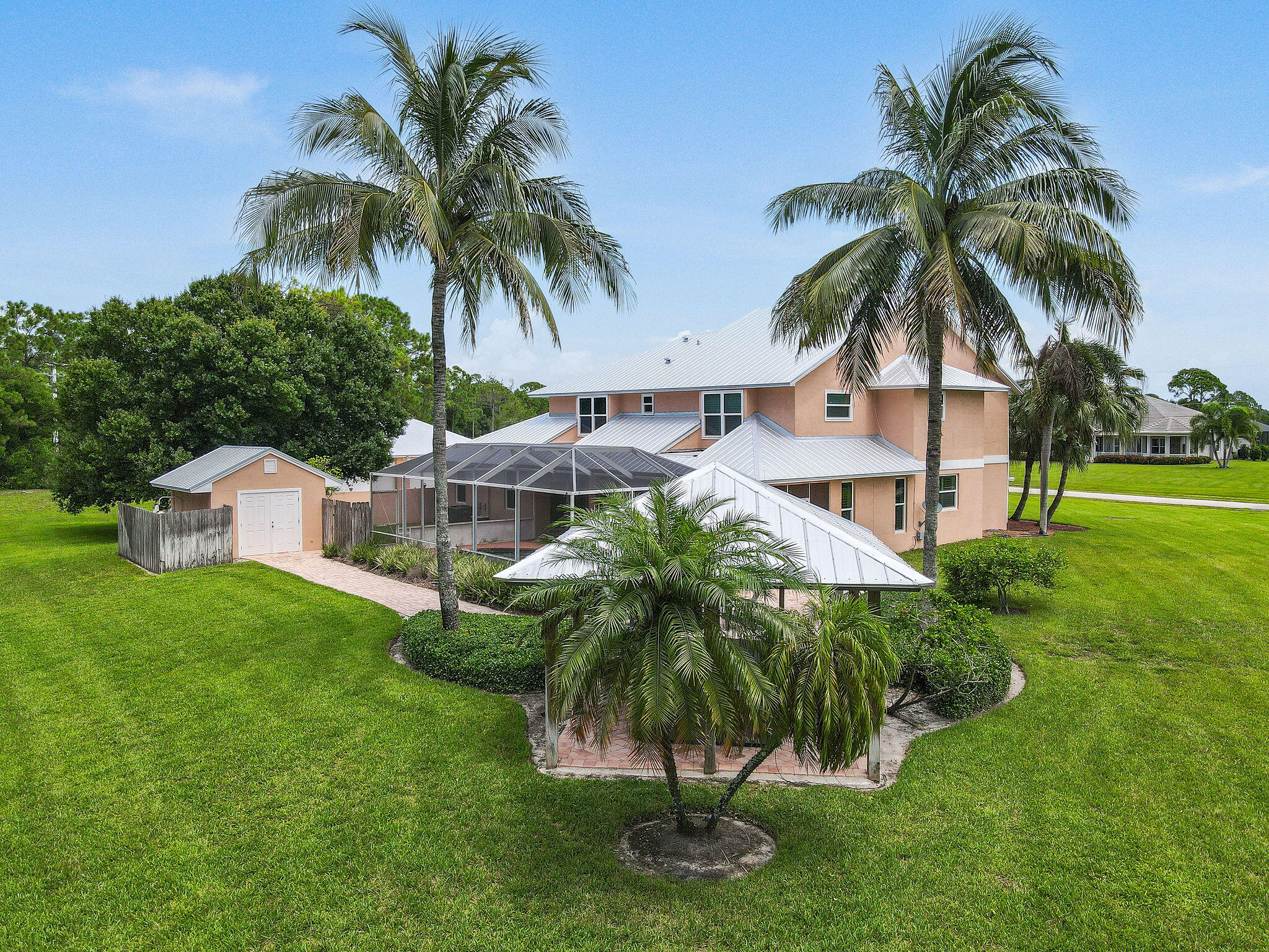 a view of a house with a yard and palm trees