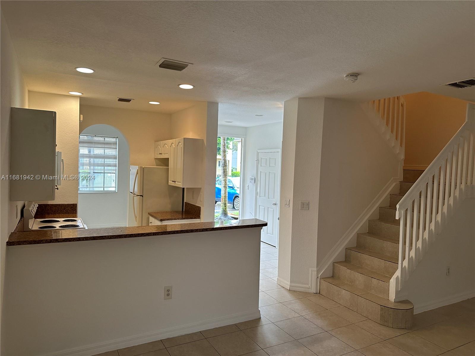 a kitchen with kitchen island granite countertop a sink a counter top space and cabinets