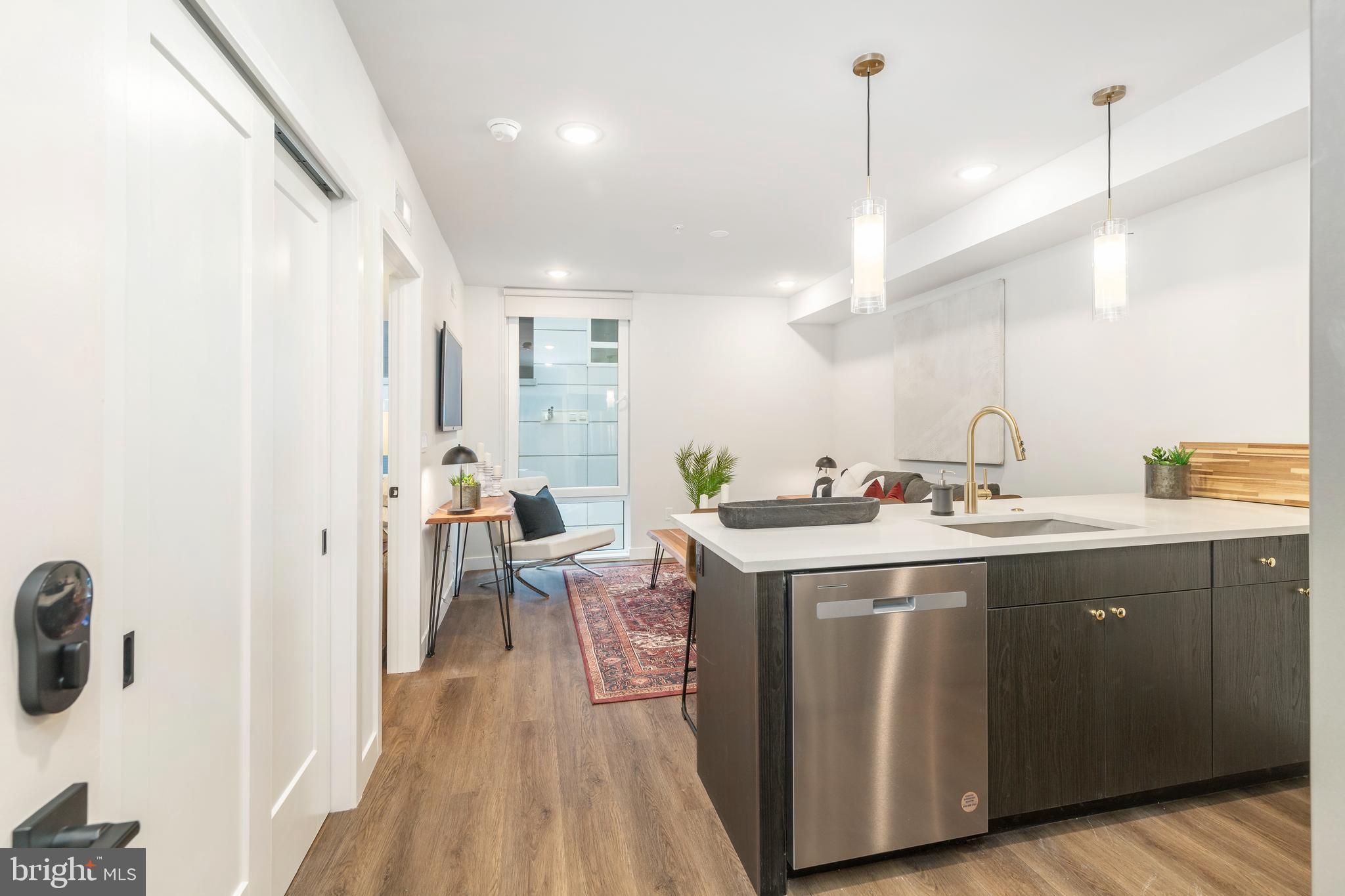 a kitchen with a sink a counter space and wooden floor