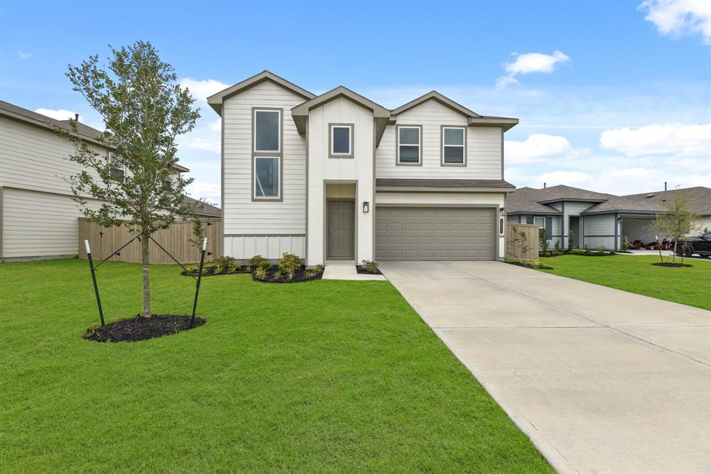 a front view of a house with a yard and trees