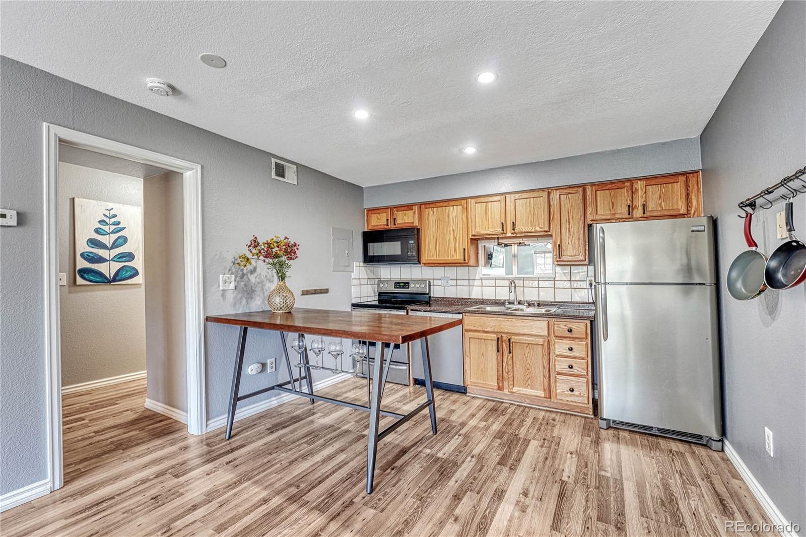 a kitchen with refrigerator cabinets and wooden floor