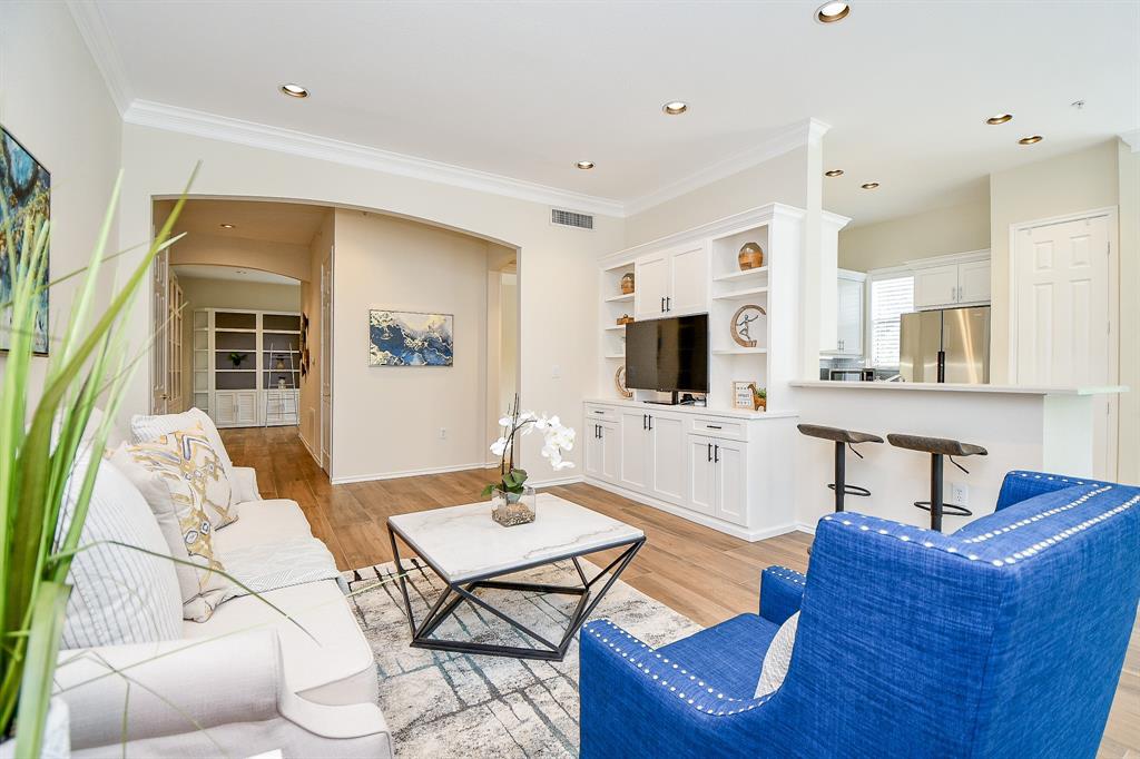 a living room with furniture a flat screen tv and kitchen view