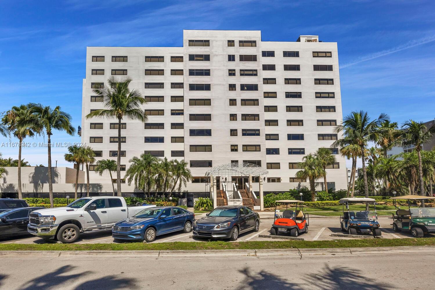 a front view of a building with cars parked