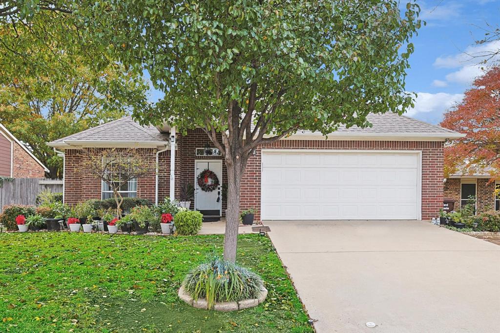 View of front facade with a garage and a front lawn