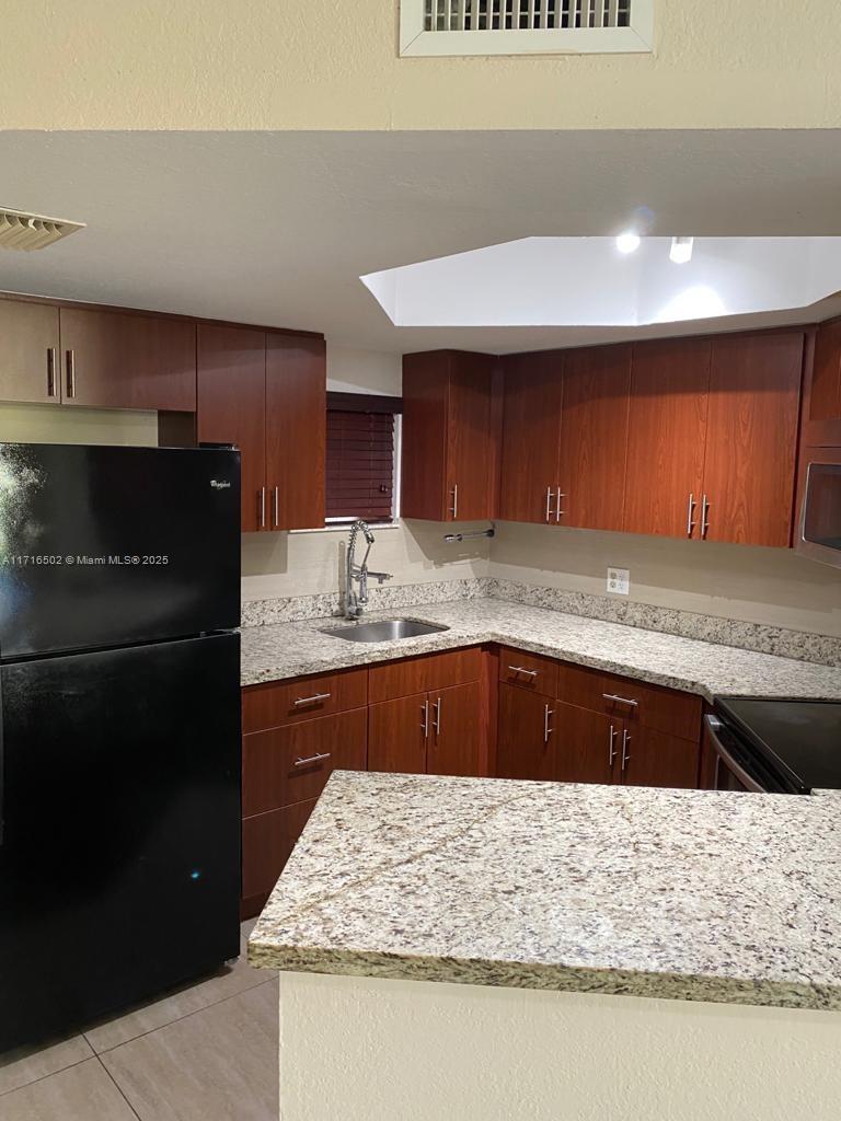 a kitchen with stainless steel appliances granite countertop wooden cabinets and a counter top