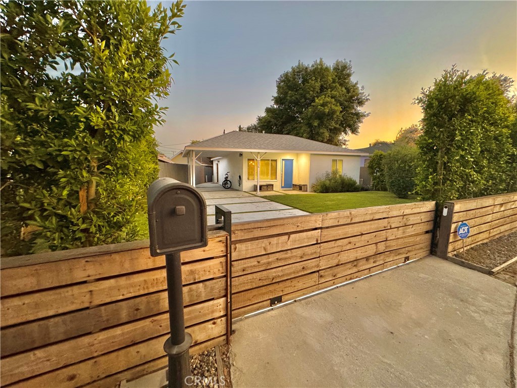 a view of a house with a small yard and wooden fence