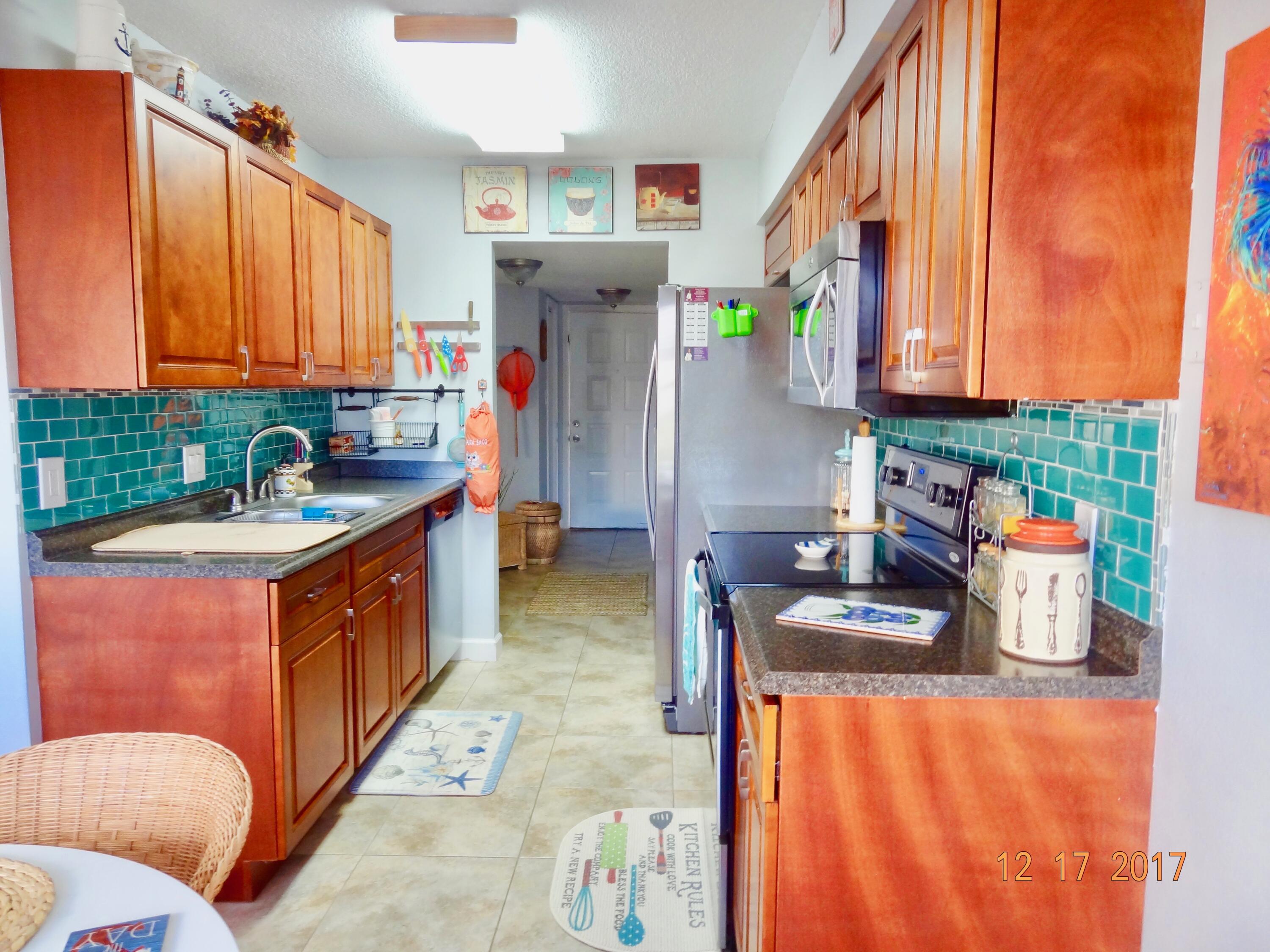 a kitchen with stainless steel appliances granite countertop a sink and a refrigerator