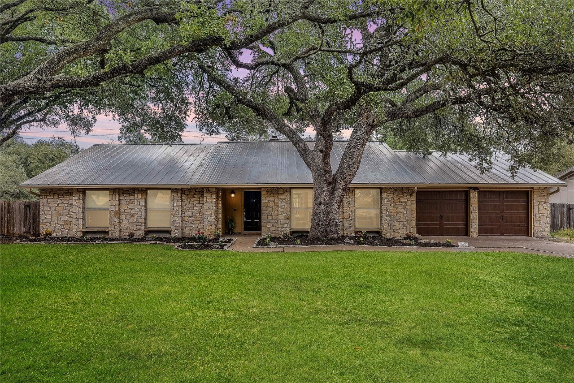 a front view of a house with a yard and trees