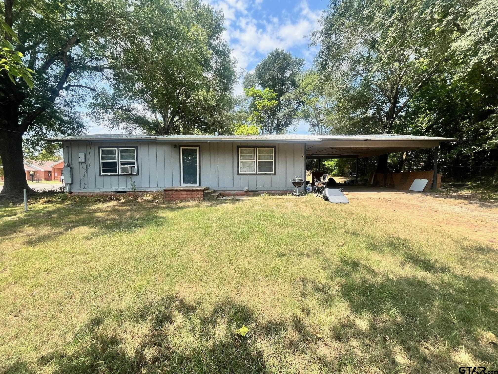 a view of a house with yard and sitting area