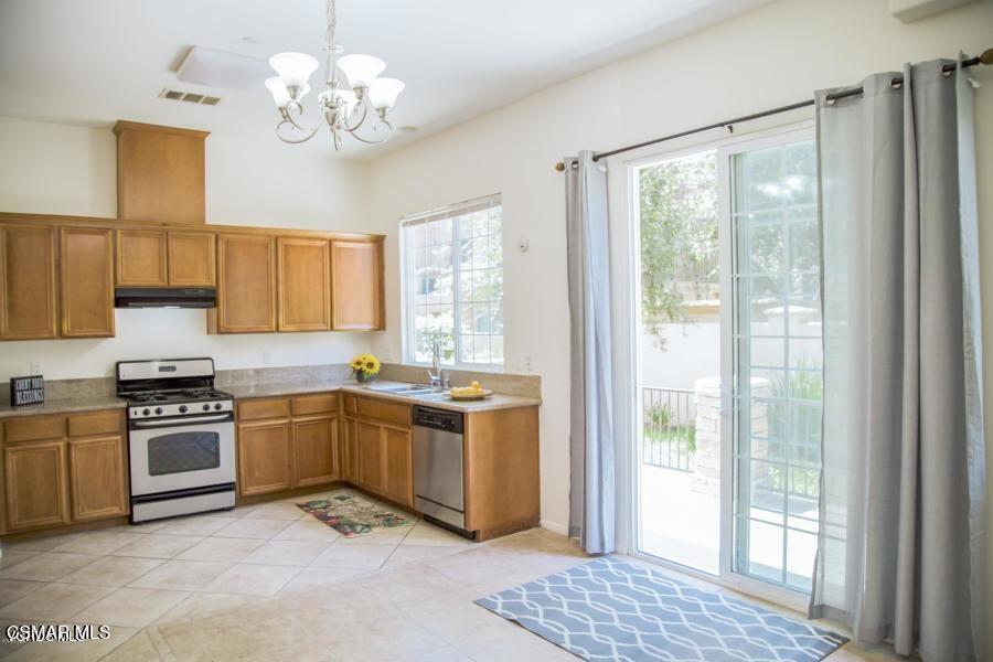 a kitchen with stainless steel appliances granite countertop a stove sink and refrigerator