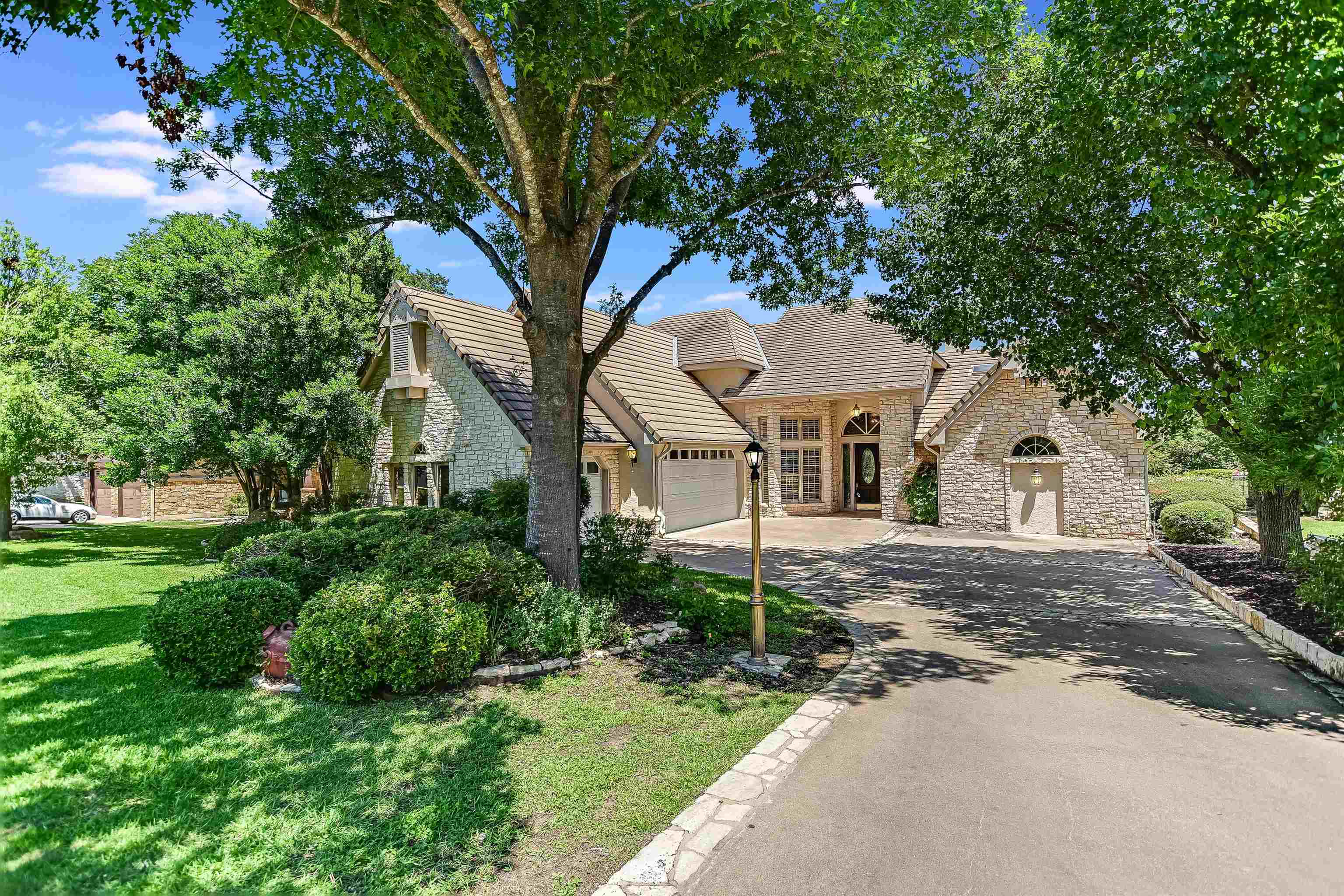 a front view of a house with a garden and trees