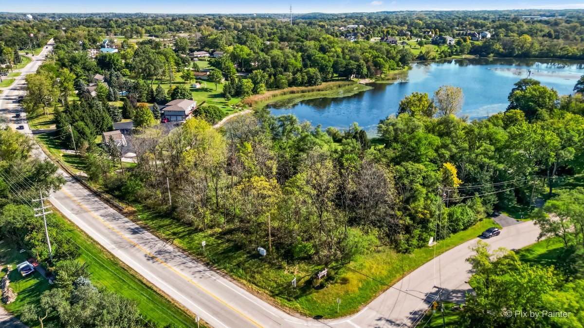 an aerial view of residential houses with outdoor space and lake view