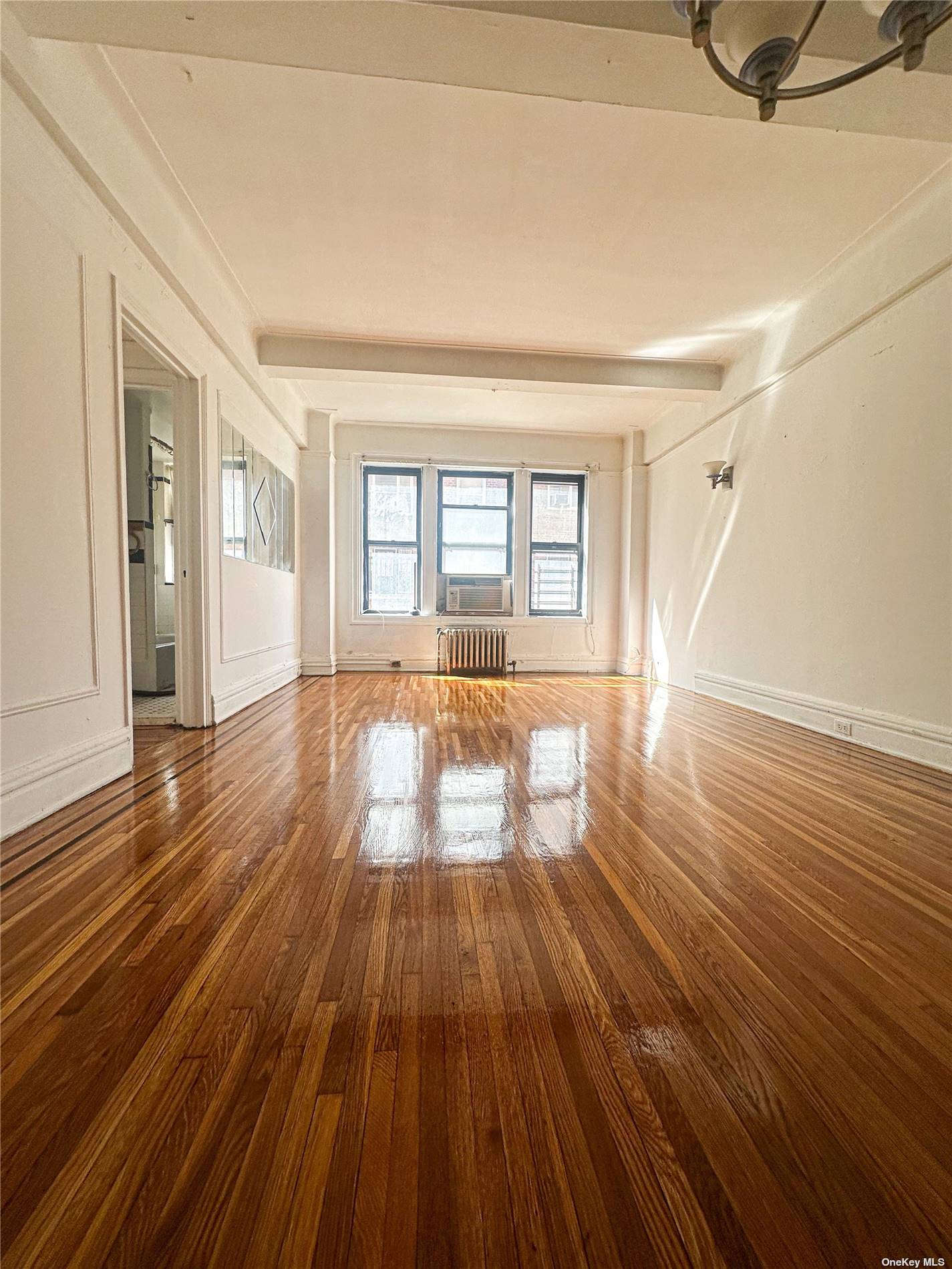 a view of empty room with wooden floor