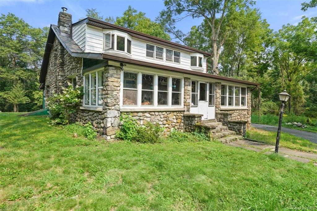 a view of a house with a yard and sitting area