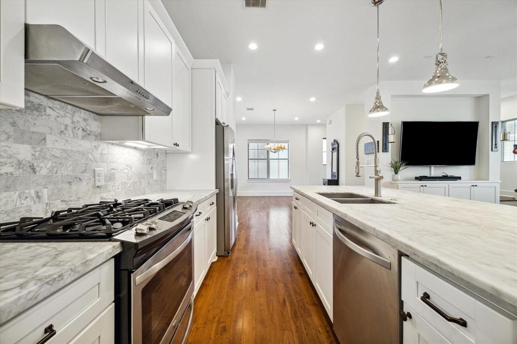 a kitchen with stainless steel appliances kitchen island granite countertop a stove a sink and a microwave