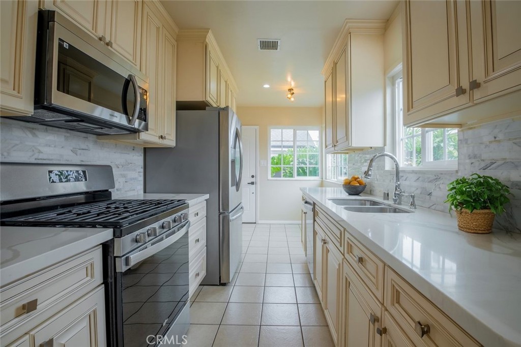 a kitchen with stainless steel appliances a stove a sink a microwave and cabinets