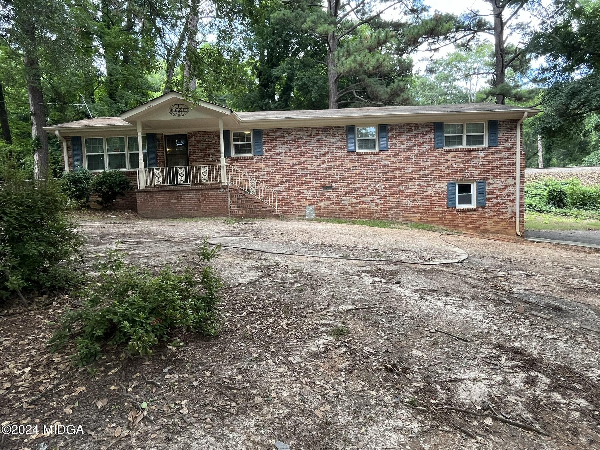 a front view of a house with yard and trees