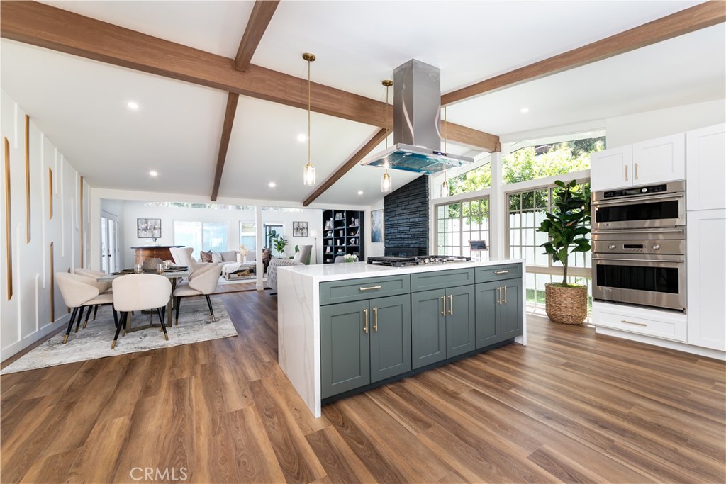 a kitchen with stainless steel appliances granite countertop a stove and a wooden floors