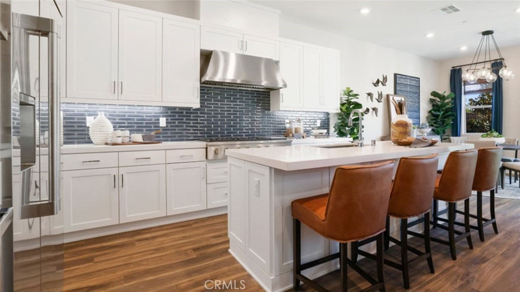 a kitchen with stainless steel appliances granite countertop a sink a stove a table and chairs