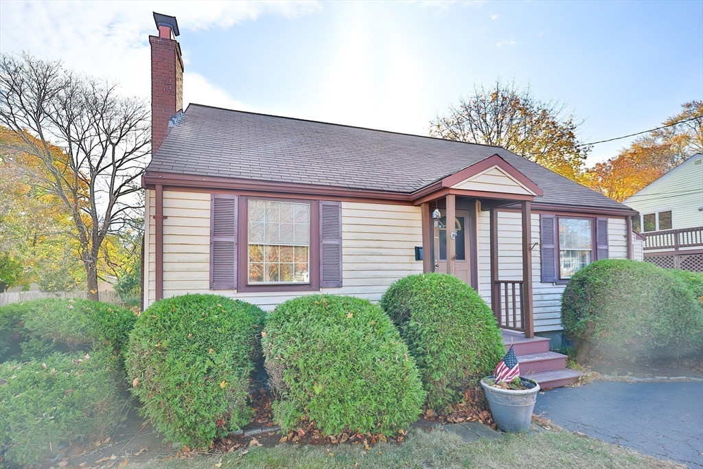 a view of a brick house with a yard and plants