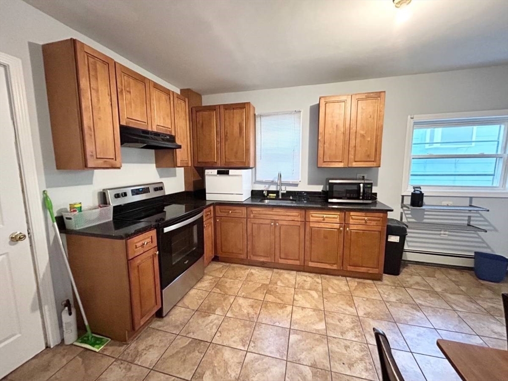 a kitchen with stainless steel appliances granite countertop a stove a sink and a microwave