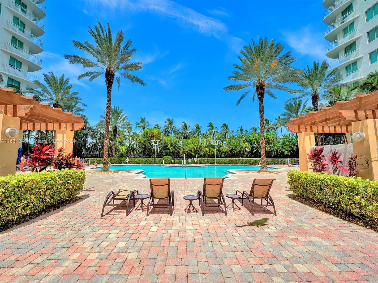 a view of a swimming pool with chairs and table in the patio