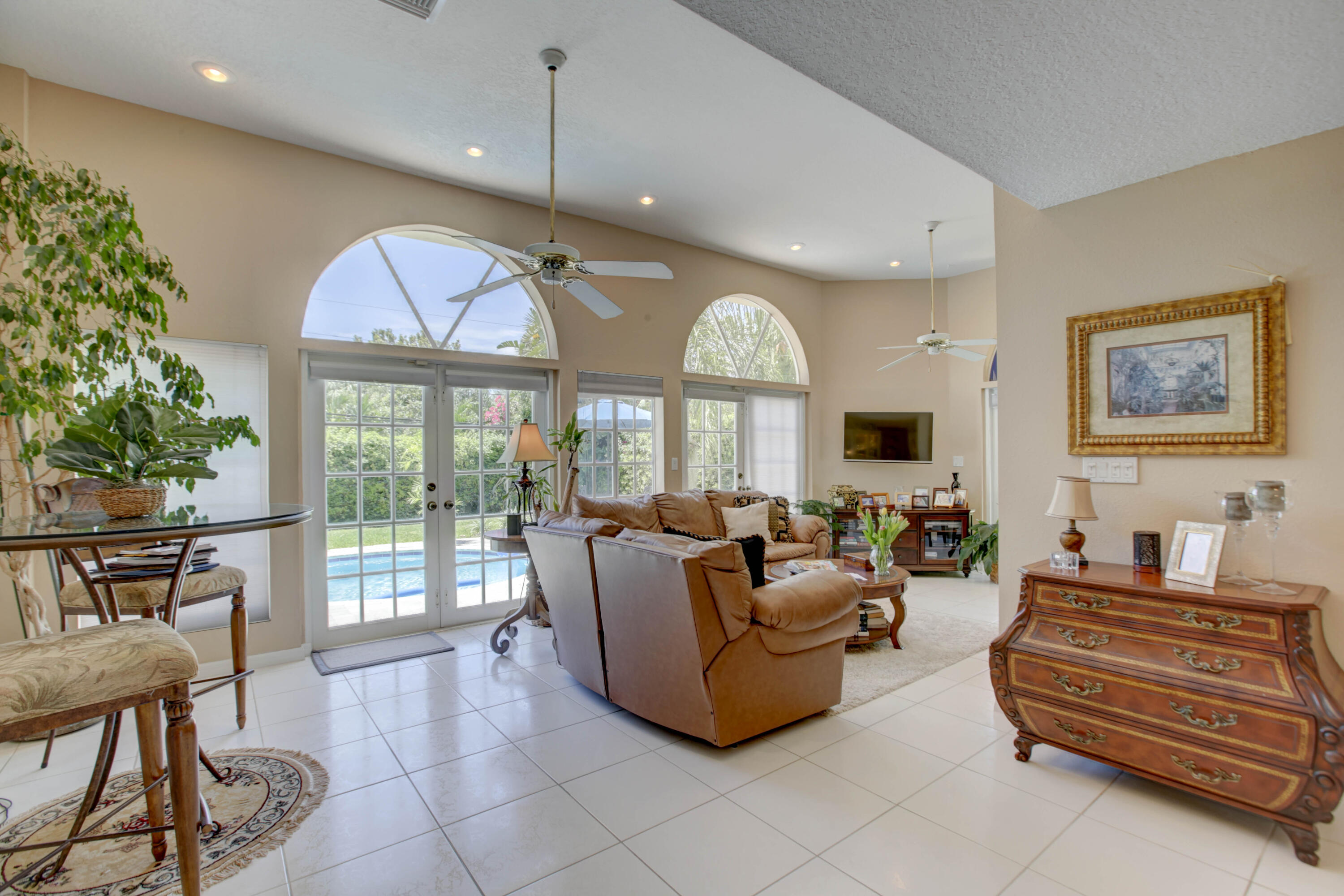 a living room with furniture a flat screen tv and a large window