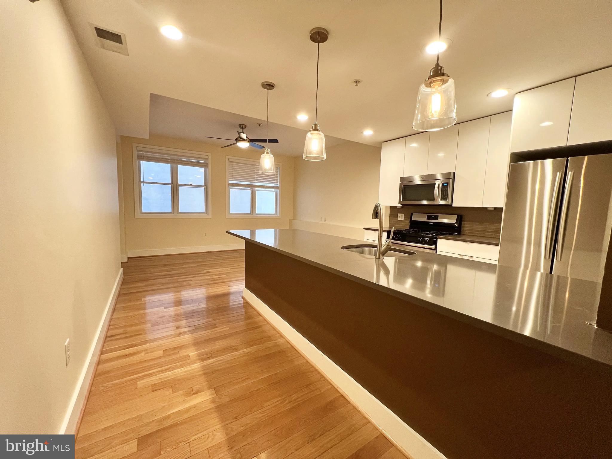 a large kitchen with kitchen island a counter space a sink and appliances