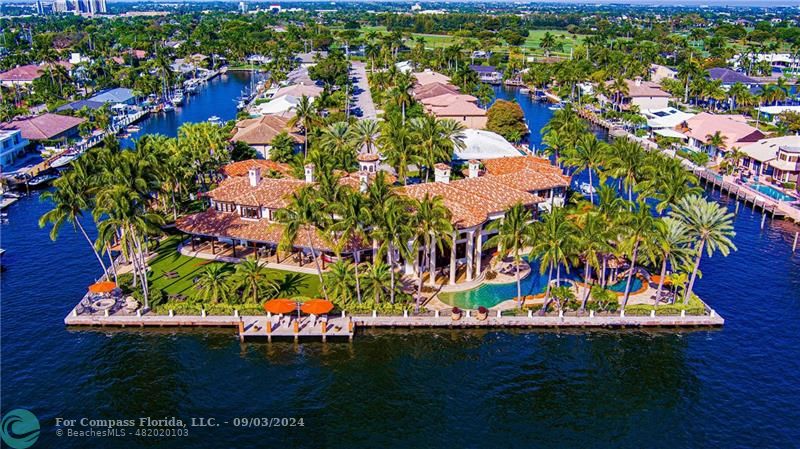 an aerial view of a house with a garden and lake view