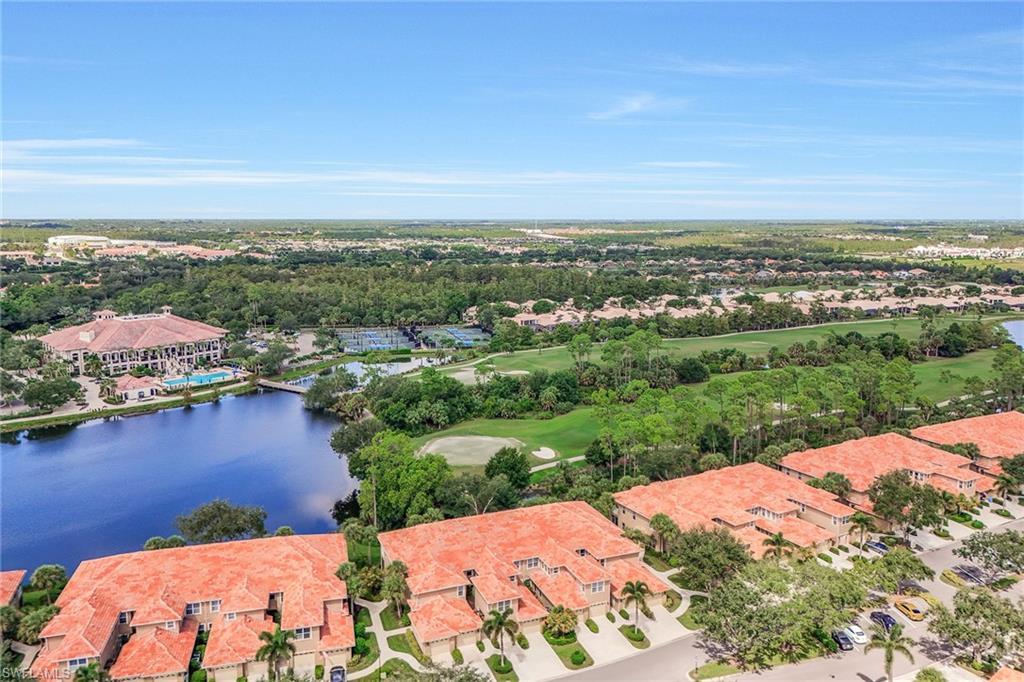 an aerial view of ocean and residential houses with outdoor space