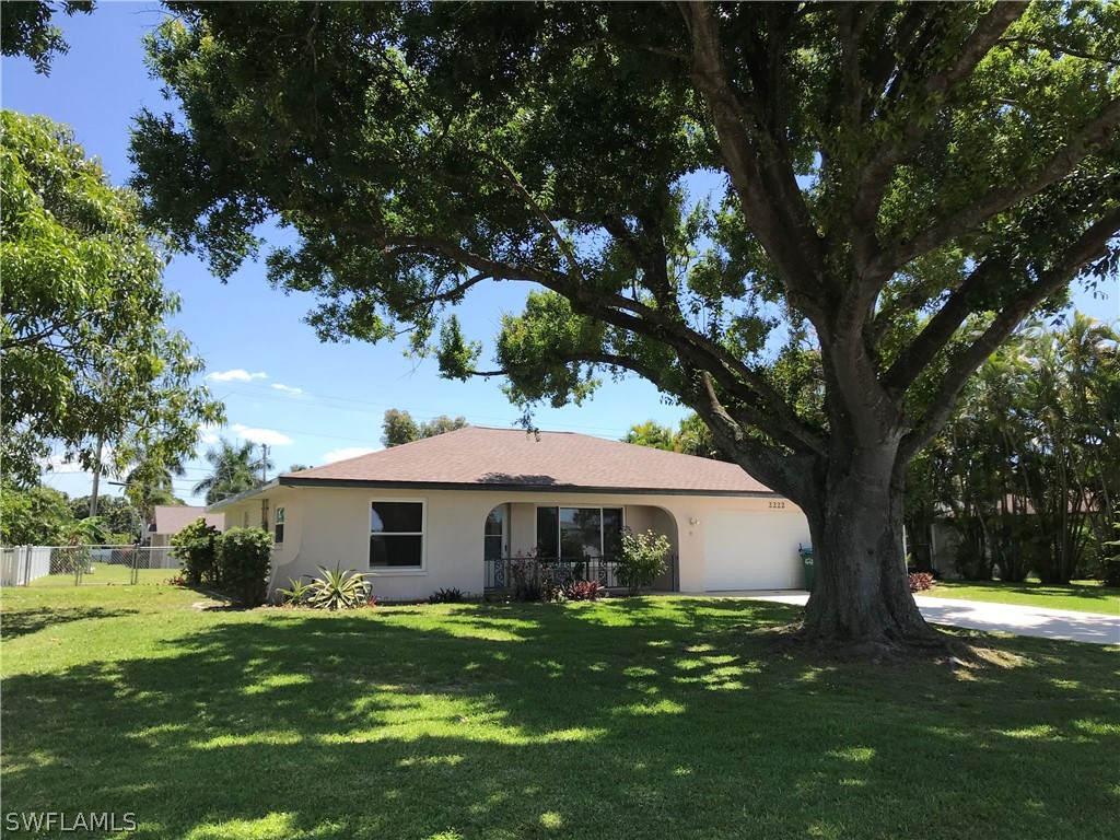 a front view of house with yard and trees