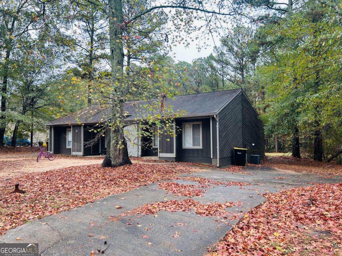 a front view of a house with a yard and trees