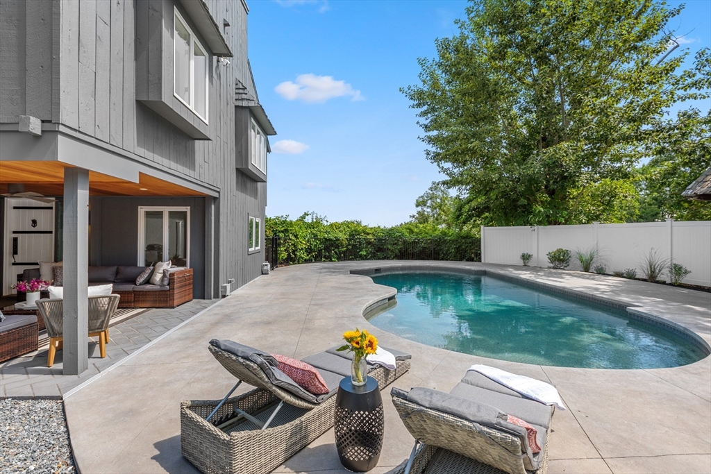 a view of swimming pool with outdoor seating and plants