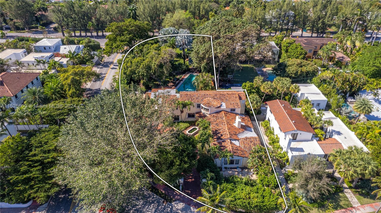 an aerial view of residential house with outdoor space and trees all around