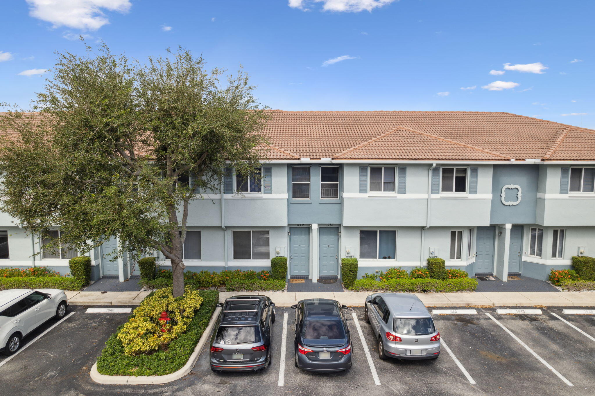 a front view of a house with cars parked