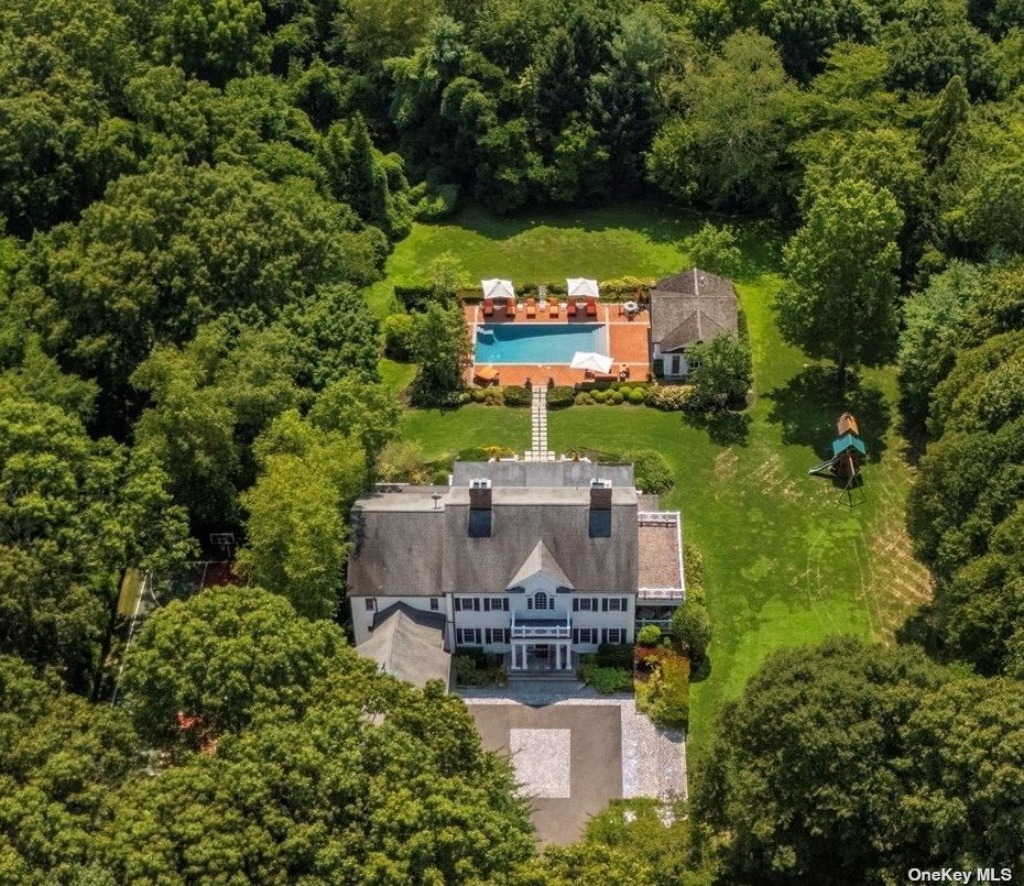 an aerial view of a house with a garden and lake view